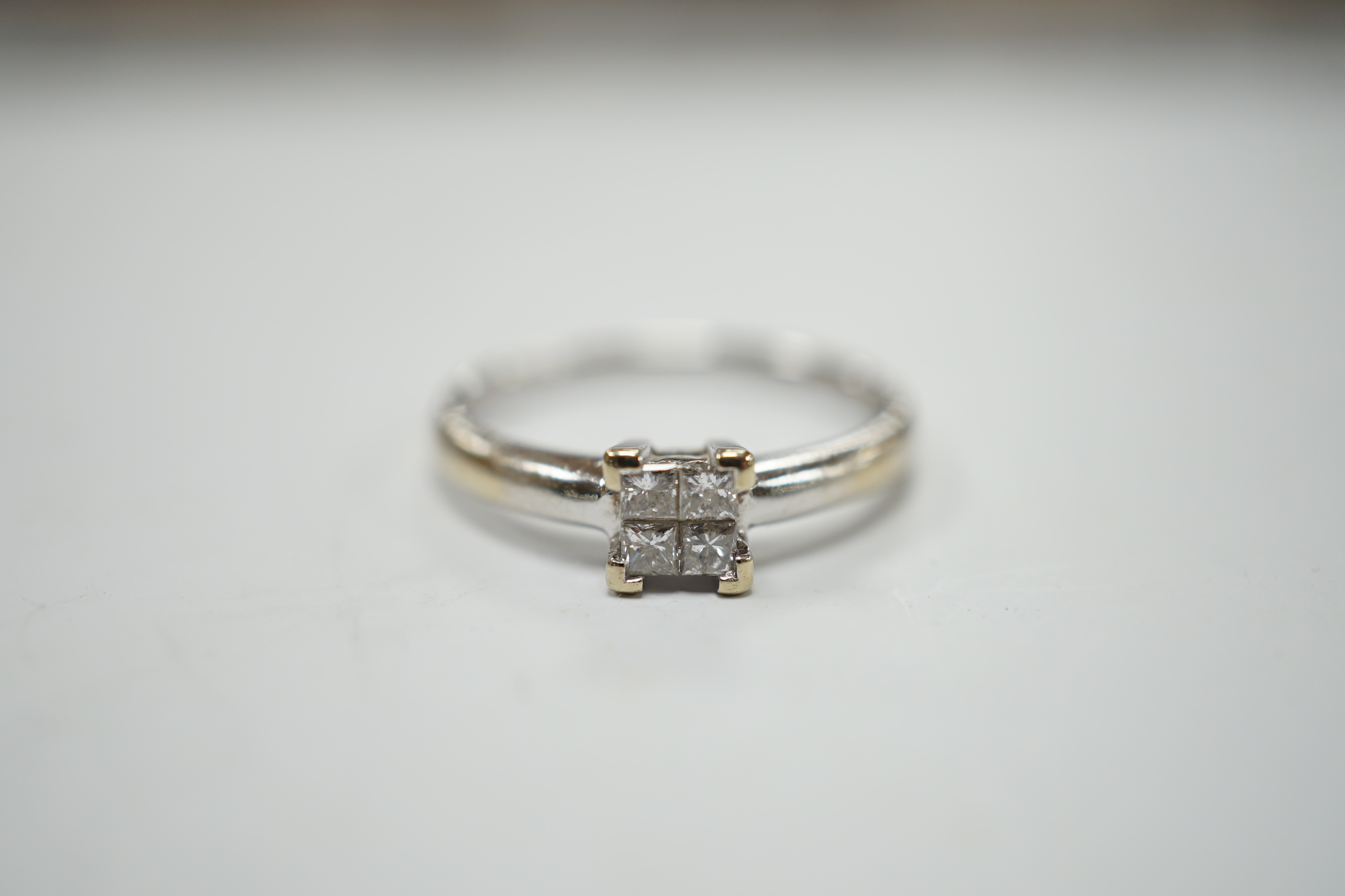 A modern 18ct white gold and four stone diamond set square cluster ring, size P/Q, gross weight 3.2 grams.